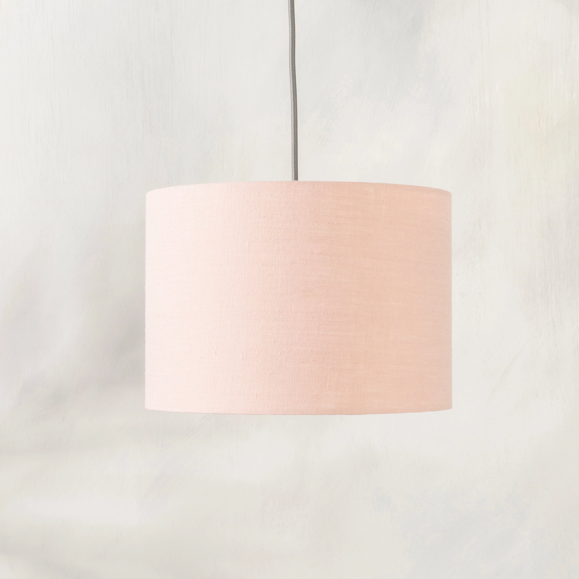 Blush pink lampshade hanging from ceiling