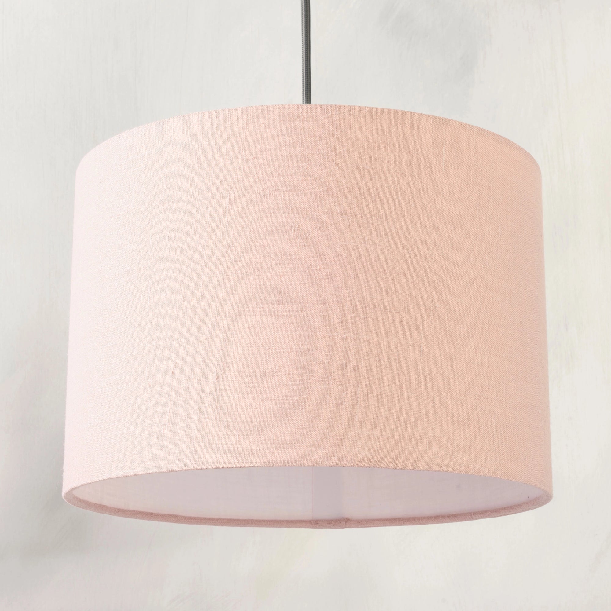 Blush pink pendant lampshade hanging from ceiling