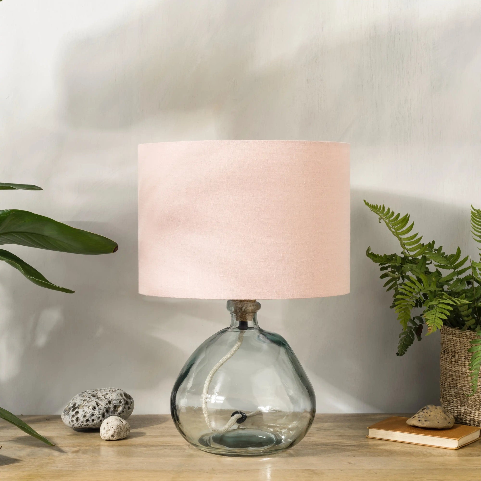 Blush pink lampshade on recycled glass base with baskets of plants