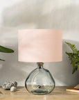 Blush pink lampshade on recycled glass base with baskets of plants